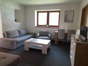 uma sala de estar com um sofá e uma mesa em Penzion V Maštali em Kněževes
