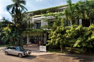 a car parked in front of a building with palm trees at Viroth's Hotel in Siem Reap