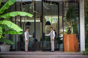 two men standing in front of a glass building at Viroth's Hotel in Siem Reap