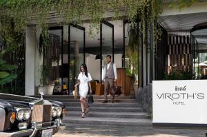 een man en een vrouw die de trap van een gebouw aflopen bij Viroth's Hotel in Siem Reap
