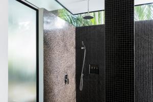 a bathroom with a shower with black tile at Viroth's Hotel in Siem Reap