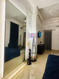 uma sala de estar com um grande espelho e um sofá em J’s Inn- A petite paradise em Guwahati