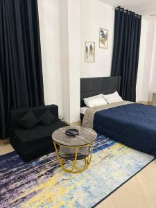 um quarto com uma cama, uma mesa e um sofá em J’s Inn- A petite paradise em Guwahati
