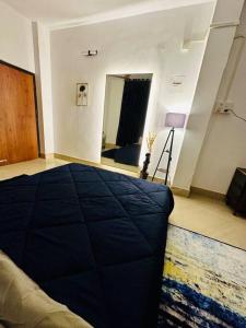 um quarto com uma cama azul e um espelho em J’s Inn- A petite paradise em Guwahati
