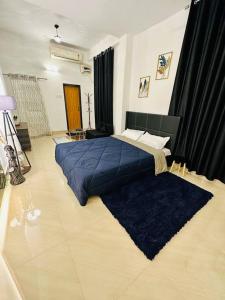 um quarto com uma cama grande e um cobertor azul em J’s Inn- A petite paradise em Guwahati