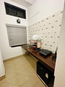 uma cozinha com um balcão com um telefone em J’s Inn- A petite paradise em Guwahati