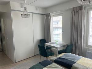 una camera da letto con tavolo, sedie e un letto di A studio near to Airport a Vantaa