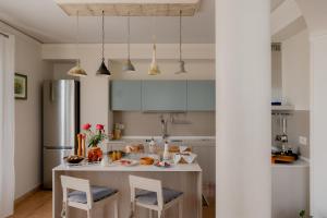a kitchen with a table with chairs and a refrigerator at Ai Quattro Ulivi B&B in Monte Urano