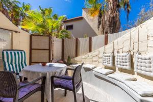 een patio met een tafel en stoelen en een hek bij Gmar House relax y naturaleza in Parque Holandes