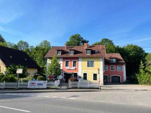 a house with a white fence in front of a street at Lindenhof Ybbs in Ybbs an der Donau