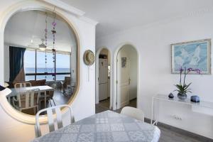 a dining room and living room with a table and a mirror at Patalavaca Beach House in Patalavaca
