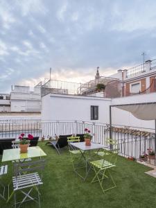 eine Terrasse mit Tischen und Stühlen auf dem Dach in der Unterkunft Apartamentos Los Venerables in Sevilla