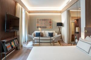 una camera d'albergo con un letto e un soggiorno di Meliá Granada a Granada
