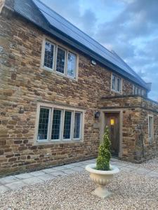 a brick house with a vase in front of it at Maple House in Faxton