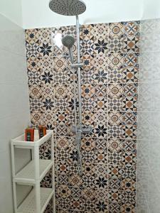 La salle de bains est pourvue d'une douche et d'un mur carrelé. dans l'établissement Cosy flat next to Andrassy Av, à Budapest