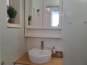 La salle de bains est pourvue d'un lavabo blanc et d'un miroir. dans l'établissement Cosy flat next to Andrassy Av, à Budapest