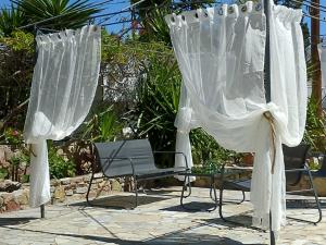 um par de cadeiras e cortinas num pátio em Marilen em Livadia