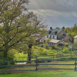 a farm with a fence and houses in the background at La Maison de Fleurat in Domeyrot +31 photos