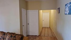 a hallway with two white doors and a couch at Villas La Romana #2 in La Ceiba