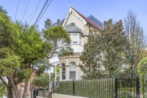 uma casa com uma cerca em frente em Victorian Apartment in Lifestyle Hotspot em Sydney