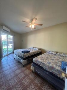 1 Schlafzimmer mit 2 Betten und einem Deckenventilator in der Unterkunft Villas La Romana #2 in La Ceiba
