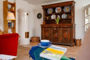 una sala de estar con un armario de madera con placas. en Haus Jölhuk, en Morsum