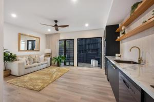 Ridge Retreat في توومبا: مطبخ وغرفة معيشة مع أريكة ومروحة سقف