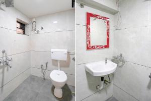 a bathroom with a toilet and a sink and a mirror at FabHotel Saroj Inn in Nashik