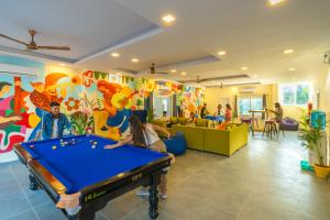a room with a pool table in a room with people at The Social Stays Rishikesh in Rishīkesh
