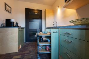 a kitchen with blue cabinets and a sink at B&B aan het Dijksteegje in Sint-Oedenrode
