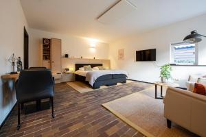 - une chambre avec un lit et un salon avec un canapé dans l'établissement B&B aan het Dijksteegje, à Sint-Oedenrode