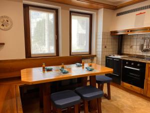 uma cozinha com uma mesa de madeira e bancos em Appartamento Marino Dolomiti Bellunesi em Belluno