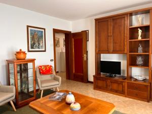 uma sala de estar com uma televisão e uma mesa em Appartamento Marino Dolomiti Bellunesi em Belluno