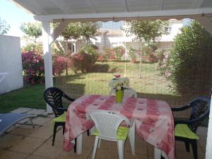 ein Tisch mit einer rosa Tischdecke auf einer Terrasse in der Unterkunft Villa climatisée T3 piscine chauffée accès direct à la plage de Prunete in Cervione + 26 Fotos