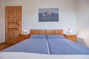 a bed in a bedroom with two night stands and a mountain at Bauerborchardt - Urlaub am Bauernhof bei Familie Borchardt in Wernberg