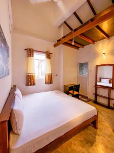 a bedroom with a large white bed and a desk at Light House View Inn - Galle Fort in Galle