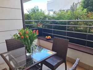 una mesa y sillas en un balcón con un jarrón de flores en Apartment Golden Sun, en Dramalj