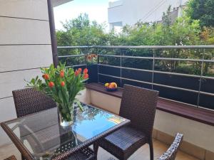 a table and chairs on a balcony with a vase of flowers at Apartment Golden Sun in Dramalj