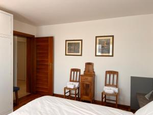 um quarto com duas cadeiras e uma cama em Appartamento Marino Dolomiti Bellunesi em Belluno