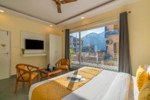 a hotel room with a bed and a large window at ArtBuzz Rishikesh in Rishīkesh