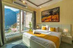 a bedroom with a bed and a large window at ArtBuzz Rishikesh in Rishīkesh