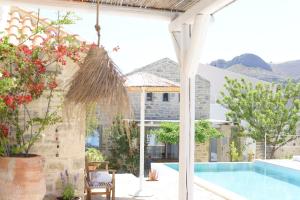 a patio with a swimming pool and a house at LAINI LUXURY SUITES in Pómbia