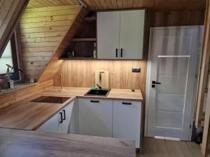 a kitchen with white cabinets and a white refrigerator at Domek na Warmii in Wernegity +6 photos
