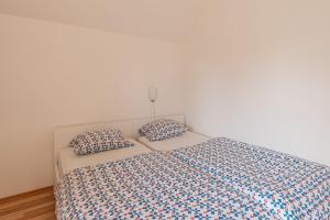 ein Schlafzimmer mit einem Bett mit zwei Kissen darauf in der Unterkunft Apartments Lavrič - Happy Rentals in Velike Bloke