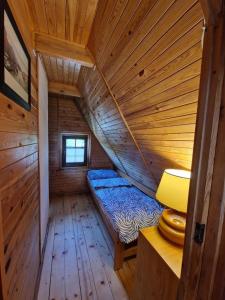 a room with a bed in a wooden cabin at Domek na Warmii in Wernegity