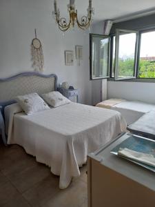 1 Schlafzimmer mit 2 Betten und einem Kronleuchter in der Unterkunft Casa moderna con jardín, 2 habitaciones in Santa Cruz de Bezana
