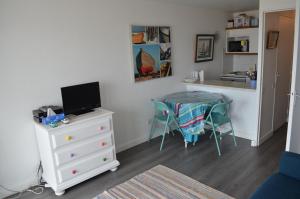 a small room with a kitchen and a table with chairs at Grand studio face mer baie de la Baule avec terrasse proche Thalasso et Parking in Pornichet
