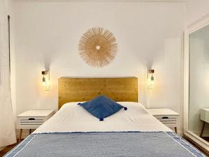 ein Schlafzimmer mit einem Bett mit einem blauen Kissen darauf in der Unterkunft meda chica in Roses