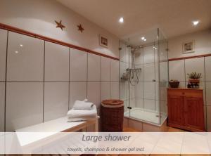 a bathroom with a shower and a bath tub at Kühles Souterrain Apartment mit privater Sauna und Terrasse in Duisburg +29 photos