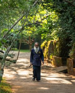 a man walking down a dirt road at Sigiriya Village in Sigiriya